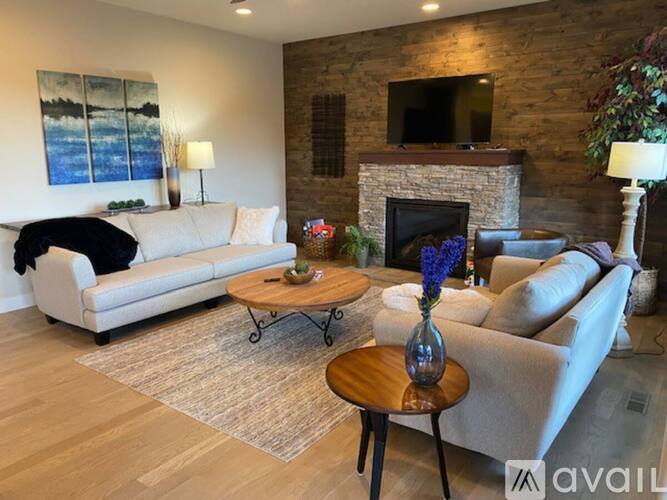 A living room with a white couch, a coffee table, and a fireplace.