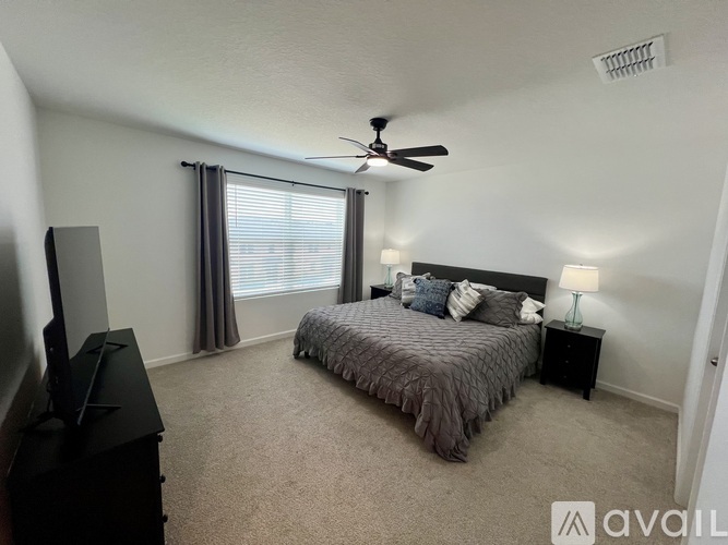 A bedroom with a bed, dresser, and television.