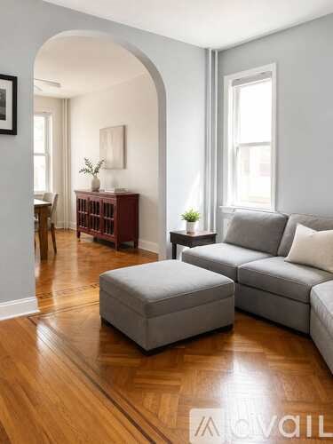 A living room with a grey couch and ottoman.