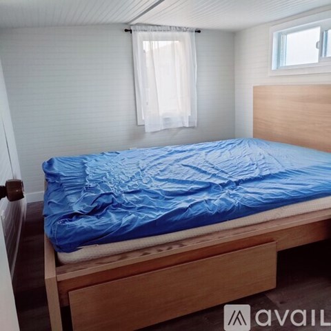 A bed with a blue comforter is in the image.