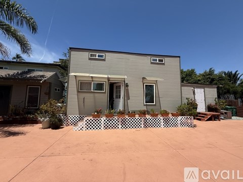 A house with a grey exterior and a white picket fence in front.