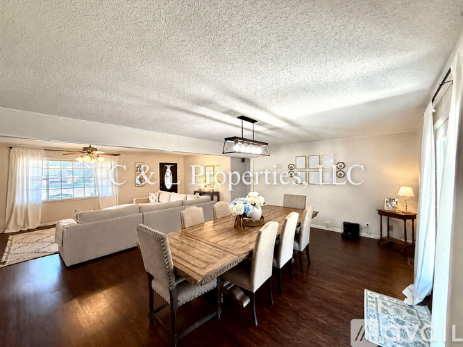 A dining room with a wooden table and chairs.