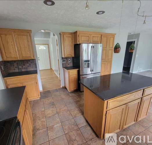A kitchen with wooden cabinets and a black countertop.