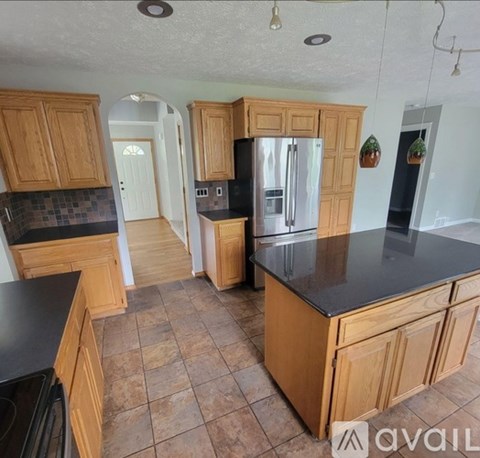 A kitchen with wooden cabinets and a black countertop.