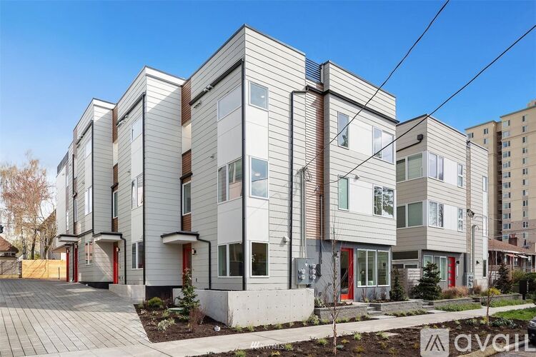 A modern apartment building with a mix of white and brown exterior walls.