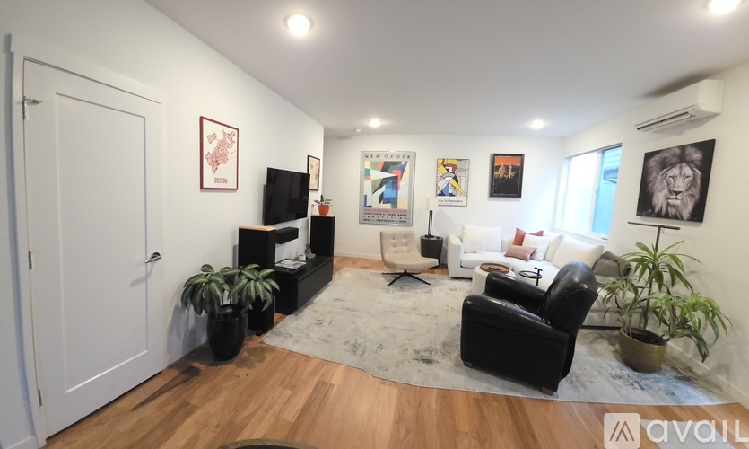 A living room with a black leather chair and a white couch.