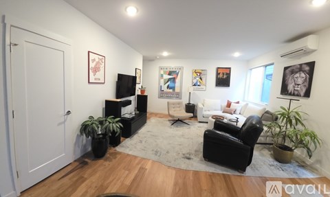 A living room with a black leather chair and a white couch.