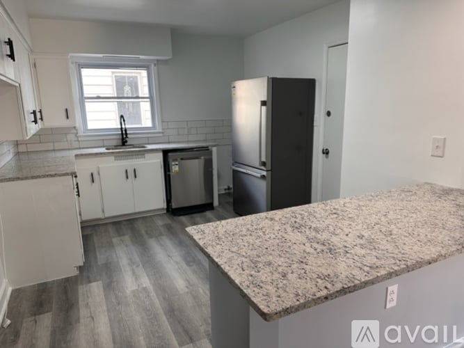 A kitchen with white cabinets and a granite countertop.