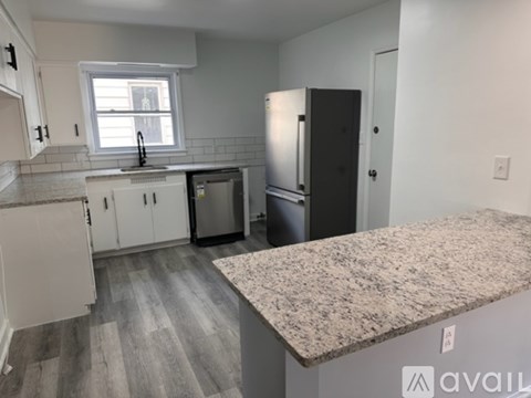 A kitchen with white cabinets and a granite countertop.