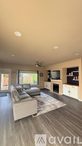 A living room with a grey couch and a television.