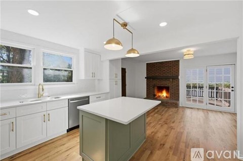 A kitchen with white cabinets and a green island.