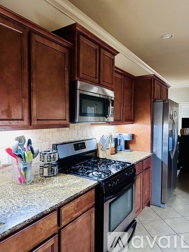 A kitchen with brown cabinets and a granite countertop.