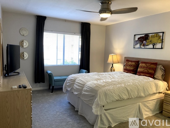 A bedroom with a large bed and a ceiling fan.