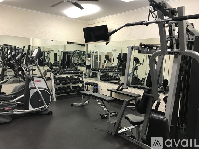 A gym with a variety of equipment including weights and a treadmill.