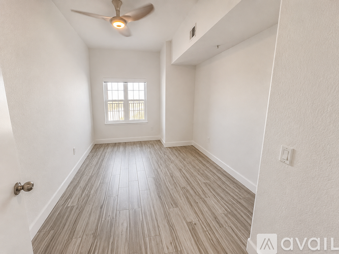 A room with a ceiling fan and a window with blinds.