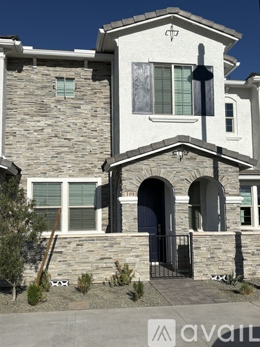 A house with a stone facade and a black gate.