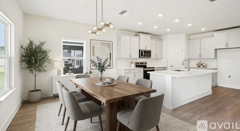A modern kitchen with a dining table and chairs.
