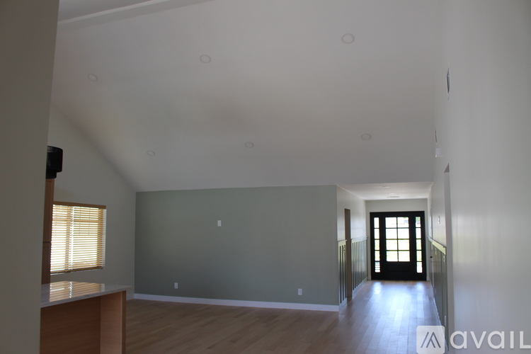 A spacious room with a door at the end of the hallway.