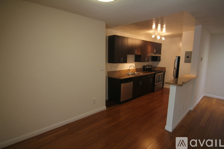 A kitchen with dark wood cabinets and a white wall.