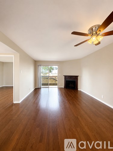 A room with wooden floors and a ceiling fan.