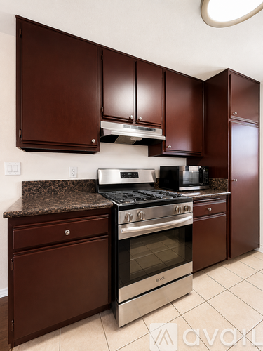 A kitchen with brown cabinets and a stainless steel oven.