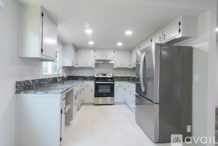 A modern kitchen with stainless steel appliances and white cabinets.