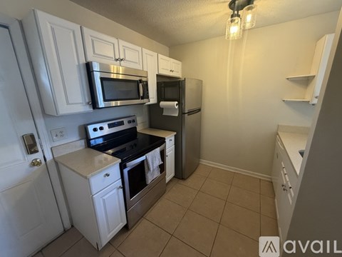 A kitchen with white cabinets and a black stove top oven.