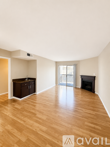 A room with wooden flooring and a fireplace.