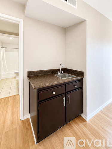 A small brown kitchen with a sink and cabinets.