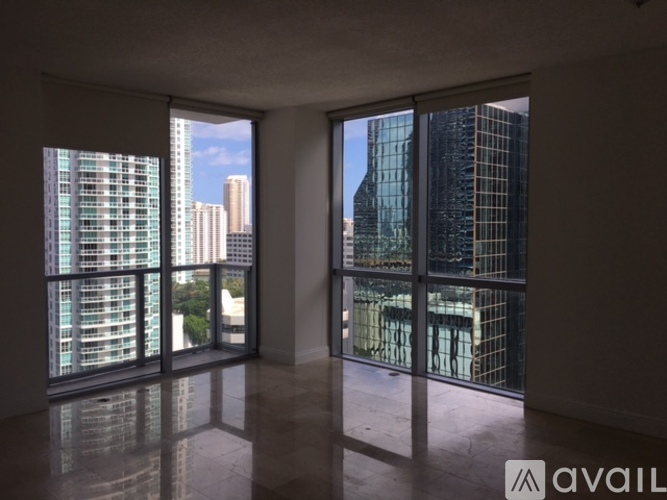 A room with large windows overlooking a cityscape.