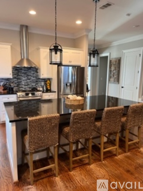 A kitchen with a dining table and chairs.