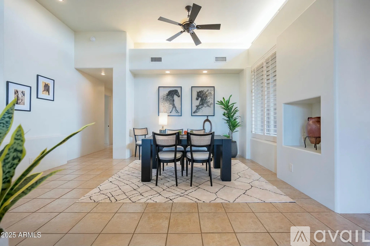 A dining room with a table set for four and a ceiling fan.