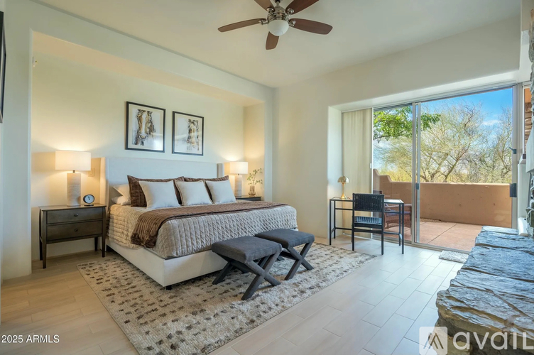 A bedroom with a large bed and a ceiling fan.