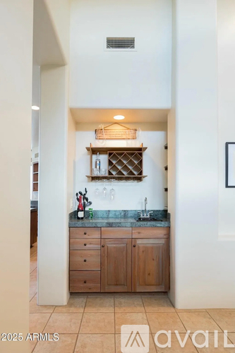A kitchen with wooden cabinets and a marble countertop.