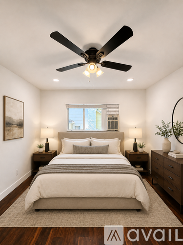 A bedroom with a large bed and a ceiling fan.