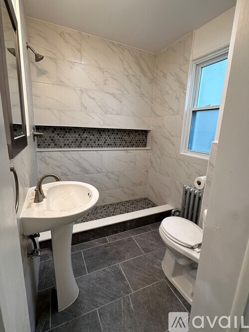 A bathroom with a white sink and toilet.