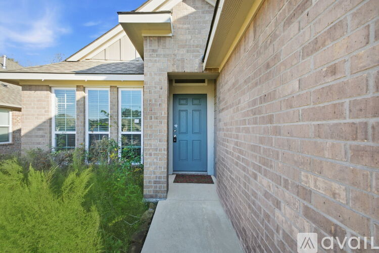 A house with a blue door and a brick wall.