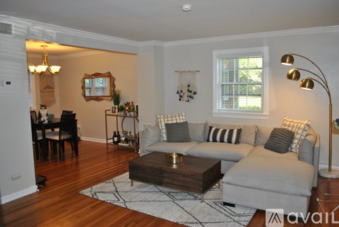 A living room with a grey couch, a coffee table, and a dining table with chairs.