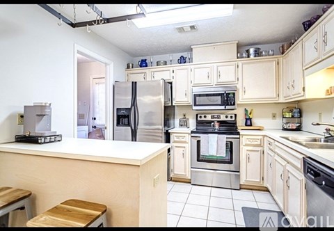 A kitchen with white cabinets and appliances.