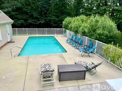 A pool with a bench and chairs around it.