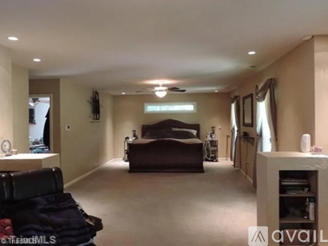 A living room with a brown couch and a black chair.