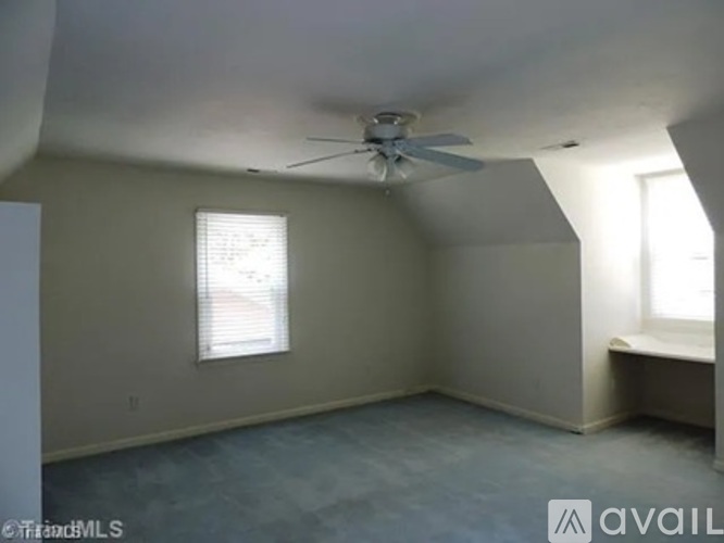 A room with a ceiling fan and a window with blinds.