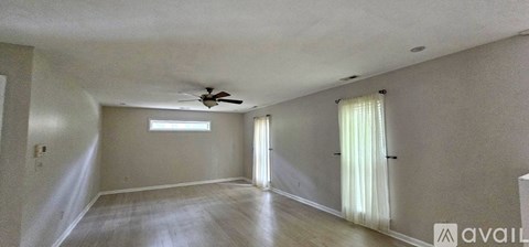 A kitchen with white cabinets and a black floor.