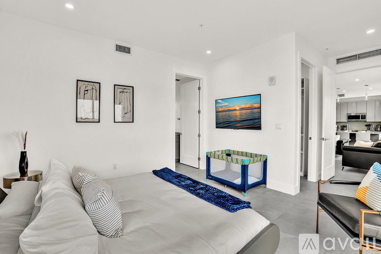 A modern bedroom with a large bed and a painting on the wall.