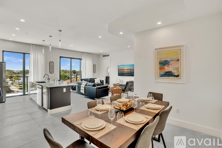 A modern dining room with a wooden table set for a meal.