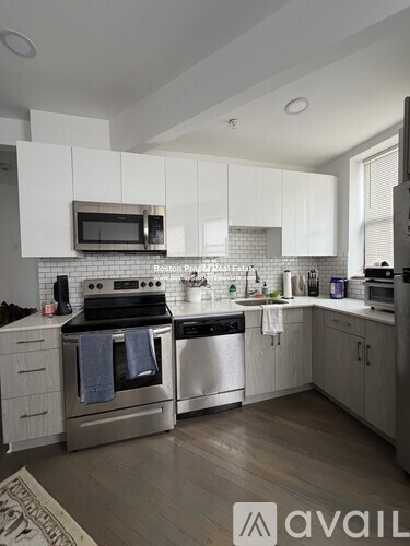 A modern kitchen with white cabinets and stainless steel appliances.