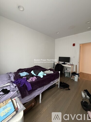 A bedroom with a bed, desk, and chair.