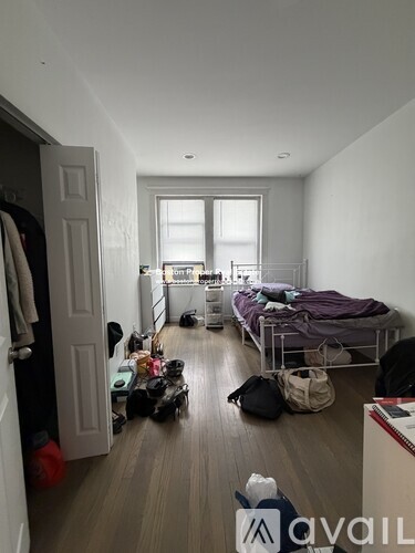 A room with a bed, a wardrobe and a window.