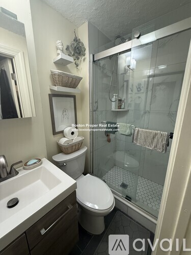 A bathroom with a toilet, sink, and shower.