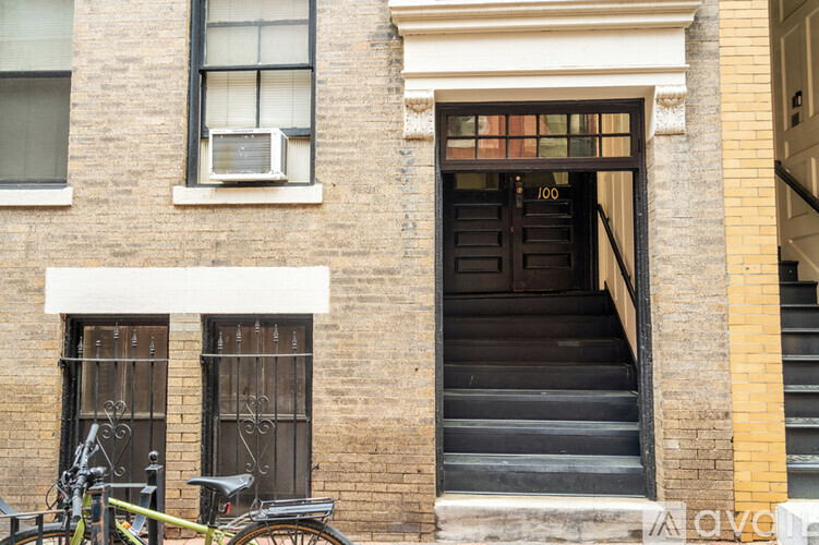 A bicycle is parked next to a window on the left side of a building.